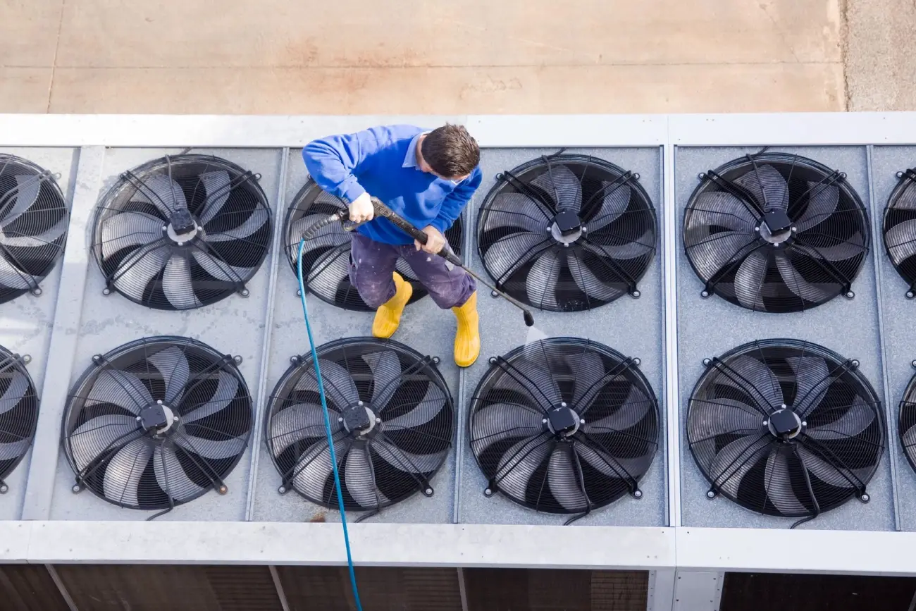 a person cleaning fans on a roof